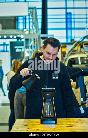 male barista pouring coffee through melitta coffee filter Stock Photo