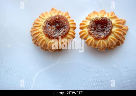 Round cookies with jam on light texture. Stock Photo