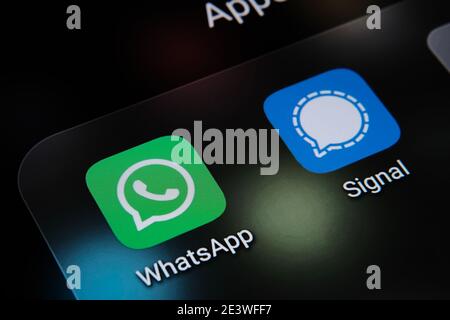 Signal and WhatsApp apps and blurred finger above them. The apps switching popularity in the United States due to secu Stock Photo