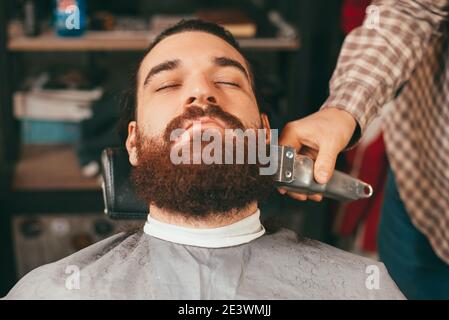 Close up photo of bearded man having haircut. Stock Photo