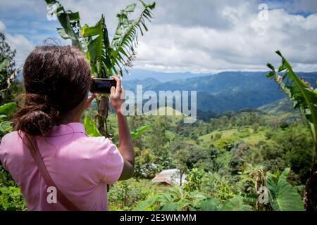 A tourist takes a picture with her smartphone of a beautiful african landscape to share it on social networks