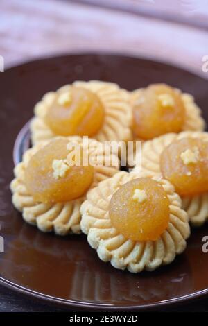 Traditional Nyonya pineapple tarts on brown saucer, festive cookies that are especially popular during Chinese New Year in Singapore & Malaysia Stock Photo