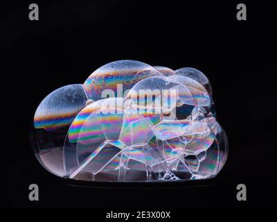 Close up soap bubbles on black background. Rainbow gradient on sides. Macro shot Stock Photo