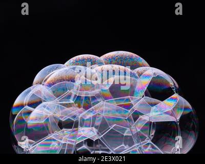 Foam bubbles with rainbow colors isolated on black background. Macro shot. Stock Photo