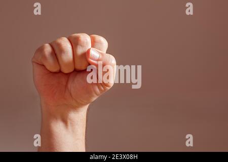 Clenched fist of a white man held high. Concept of resistance, solidarity and challenge. Stock Photo