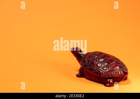Small sculpture of a terra cotta colored African tortoise walking. Stock Photo