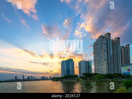 Sunset in urban areas along river with skyscrapers read shine by sky dramatic create beauty of urban development in Ho Chi Minh City, Vietnam