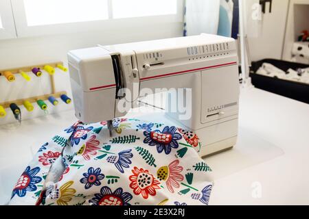 Colorful threads and sewing machine on table Stock Photo
