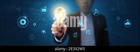 Businessman holding light bulb and new ideas of business with innovative technology network connection. Business innovation concept. Stock Photo