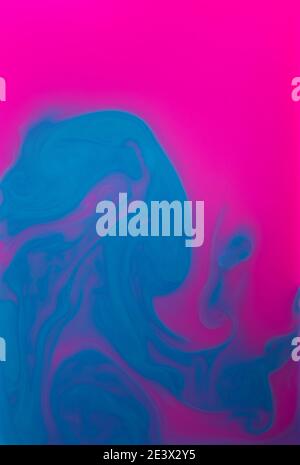 Blue and Pinlk liquids mixed together in fluid creating colorful abstract background Stock Photo