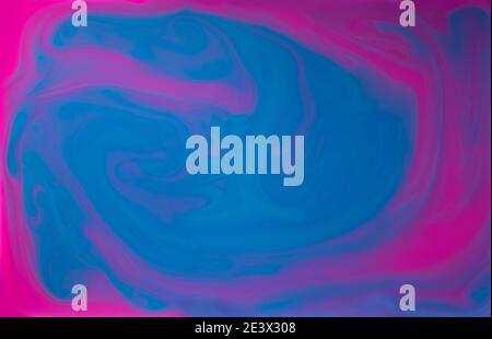 Blue and Pinlk liquids mixed together in fluid creating colorful abstract background Stock Photo