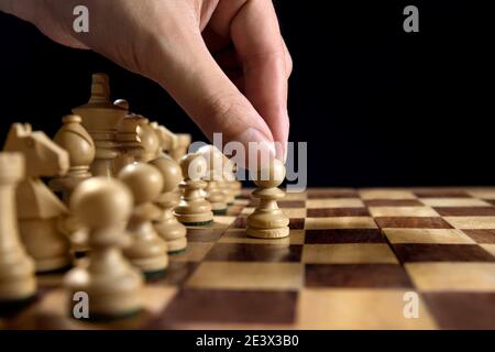 Male hand moving the black chess pawn during the game of chess Stock Photo