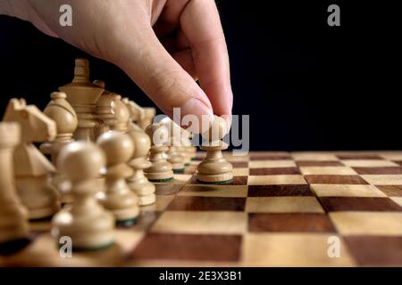 Male hand moving the white chess pawn during the game of chess Stock Photo