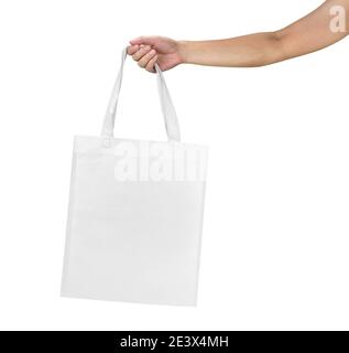 Mockup of female hand holding a blank Tote Canvas Bag isolated on white background. Stock Photo