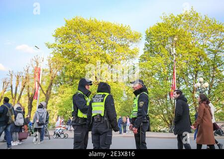 RIGA, LATVIA - MAY 4, 2020: Municipal police officers talking on the street in Riga while on patrol, the inscription on the jacket - Riga municipal po Stock Photo