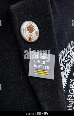 Activist displays Black Lives Matter Pin on his clothing. Activist groups in Columbus came together to form the 'United Front Against the Far-Right and Capitalist System!' This demonstration began at Columbus City Hall, marched to the Columbus Statehouse and concluded with a march back to Columbus City Hall. Left wing activist groups organized this event, because they felt they needed to make their presence known to the Far-Right after supporters of the previous president, Donald J. Trump, breached the Capitol of the United States on Jan. 6, 2021. Stock Photo