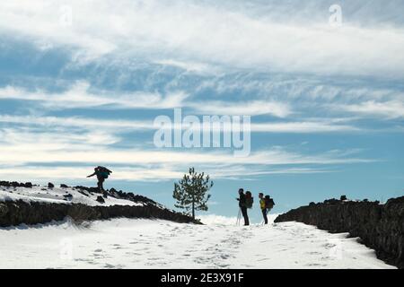 hikers taking a pictures on path snow covered of Etna Park a touristic destination of Sicily outdoor tourism and nature Stock Photo