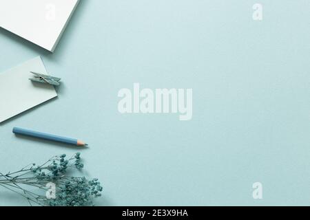 Work and study place. Notepad, colored pencil, clip on blue background. flat lay, top view, copy space Stock Photo