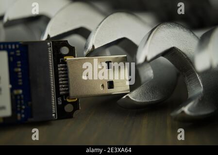 Set of spanners or wrenches in close up with jaws around a small electronic component and selective focus, technical support or smart tools concept Stock Photo