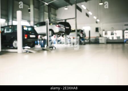 Car repair service in defocus, industrial background. Cars on lifts, transport service area. Copy space Stock Photo