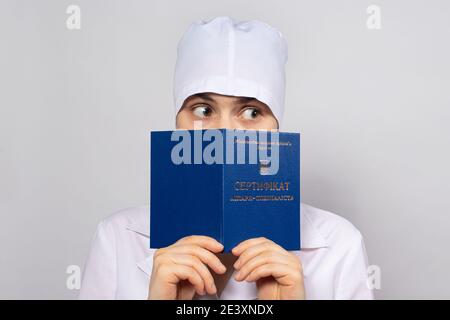 Doctor holds a diploma of higher education, a certificate of professional development by a doctor Buying a patent Stock Photo
