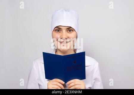 Doctor holds a diploma of higher education, a certificate of professional development by a doctor Buying a patent Stock Photo