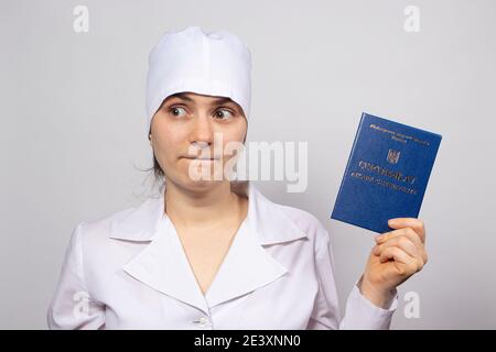 Doctor holds a diploma of higher education, a certificate of professional development by a doctor Buying a patent Stock Photo