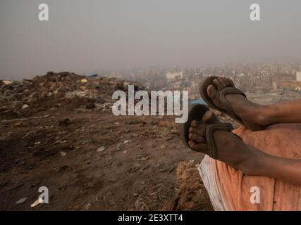 18 January 2021, India, Neu Delhi: Eleven-year-old Rickky, 11, sits on a pile of recyclable material while collecting garbage at the Bhalswa garbage dump. The fourth-grader from Malda in West Bengal, whose father works as a rickshaw driver, started working during the October 2020 lockdown as schools were closed. His family sent him to Delhi to stay with an uncle who was already working as a rag picker. Shek earns 150 rupees a day collecting recyclable material from the garbage dump. (to dpa 'Shame of the world: poverty forces millions of children to work') Photo: Vijay Pandey/dpa Stock Photo