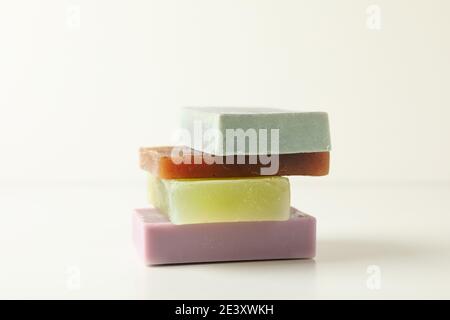 Stack of colorful pastel handmade soap bars on white, a playful natural soap tower in purple, green and gray Stock Photo
