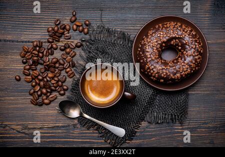 on the rustic wooden background, yummy breakfast with espresso and chocolate glazed donuts Stock Photo