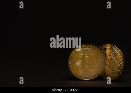 two golden shiny valuable bitcoin with front and back side with black right view Stock Photo