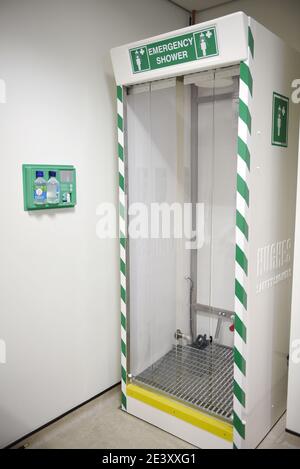 An emergency safety shower in a chemical science laboratory workplace. Also with an emergency eye wash station mounted on the wall. Stock Photo