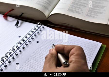 person writing on a notebook Stock Photo