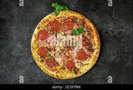 Whole neapolitan pizza served on dark board Stock Photo