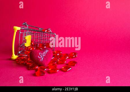 Shopping cart with glass red hearts-buying gifts for loved ones, couples in love on Valentine's day. Promotions in the holiday of lovers, products wit Stock Photo