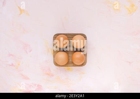 Four brown eggs in a wooden storage organizer box Stock Photo