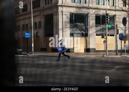 A person runs with a Biden Harris campaign sign at the spot where inauguration attendees waited in vain to see the inauguration parade of President Joe Biden and Vice President Kamala Harris. Stock Photo