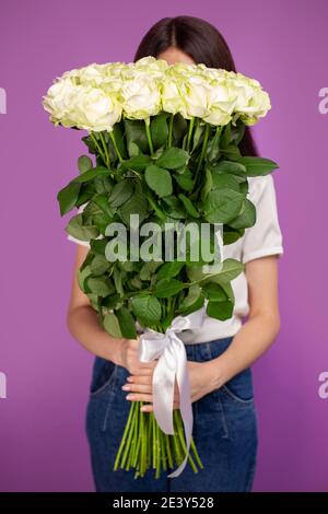The girl with big bouquet of flowers white roses in front of her Stock Photo