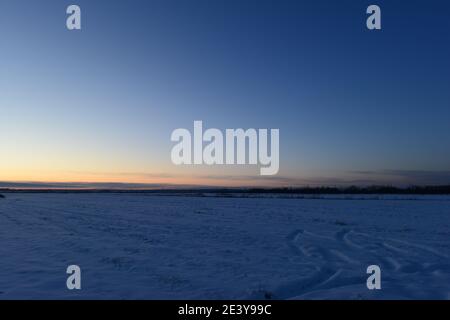 Winter dusky blue sky in a rural area over snowy fields Stock Photo
