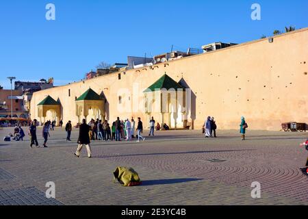 Meknes, Morocco - November 19th 2014: Unidentified people and street performer on place el-Hedim with mediecal wall Stock Photo