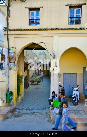 Meknes, Morocco - November 19th 2014: Unidentified people and archway to shops in courtyard Stock Photo