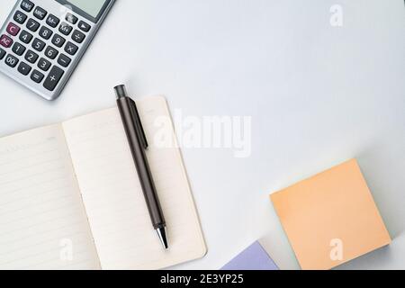 Topview of notebook with pen, calculator and sticky note Stock Photo
