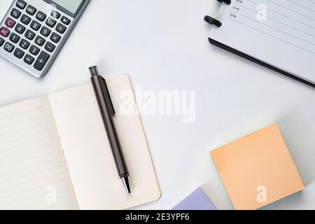 Topview of notebook with pen, calculator and sticky note Stock Photo