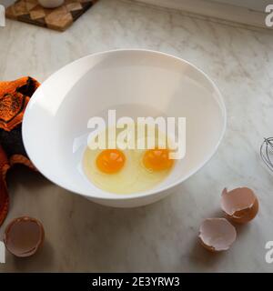 Raw eggs in a bowl for making an omelet or dough, close up Stock Photo