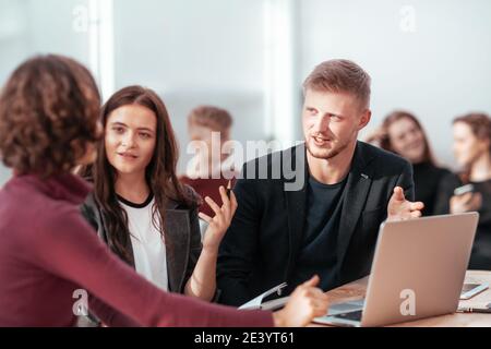 young employees discussing work issues in the workplace Stock Photo