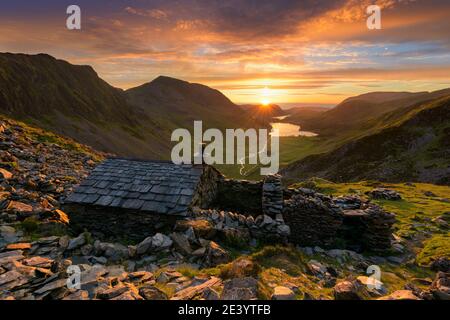 Old mountain shelter Warnscale Bothy with beautiful sunset over Buttermere in the Lake District, UK. Stock Photo