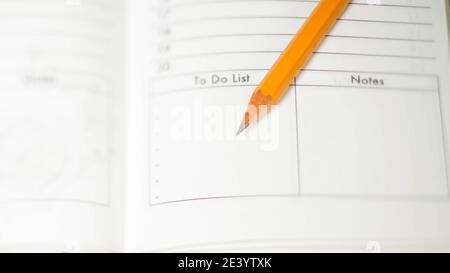 Pencil on opened diary notebook. Empty To do list and Notes. Close-up. Stock Photo