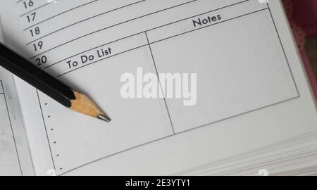 Pencil on opened diary notebook. Empty To do list and Notes. Close-up. Stock Photo