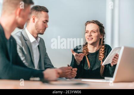 young woman showing her colleagues information on a digital tablet Stock Photo
