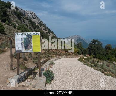 Genna Silana pass, Urzulei, Sardinia, Italy, September 19, 2020: View of tourist notice at start of hiking trail to Gola Su Gorropu gorge at green Stock Photo